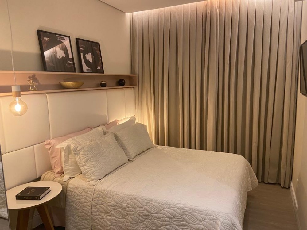 Dormitório do casal com cabeceira estofada e cortinas