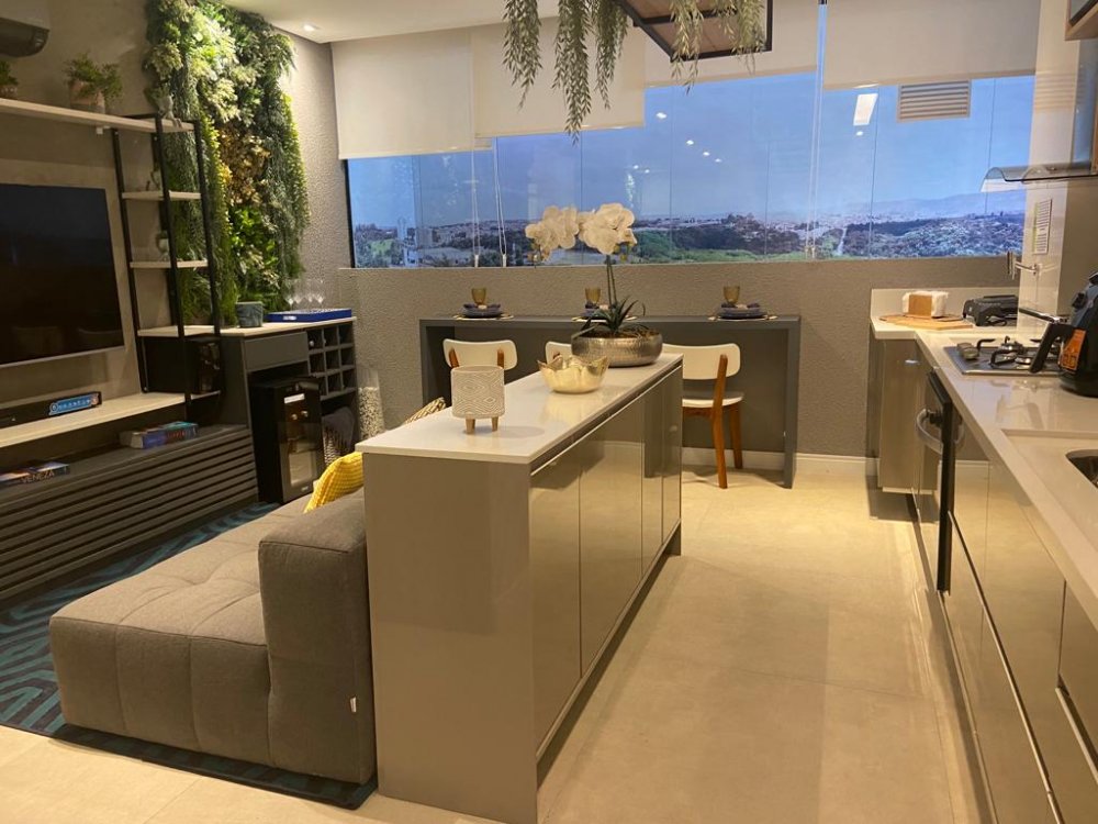 Living integrado com cozinha, painel de TV e jardim vertical