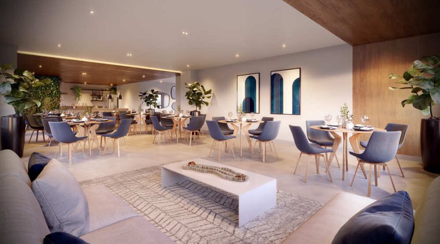 Salão de festas com mesas de jantar, poltronas azuis e lounge
