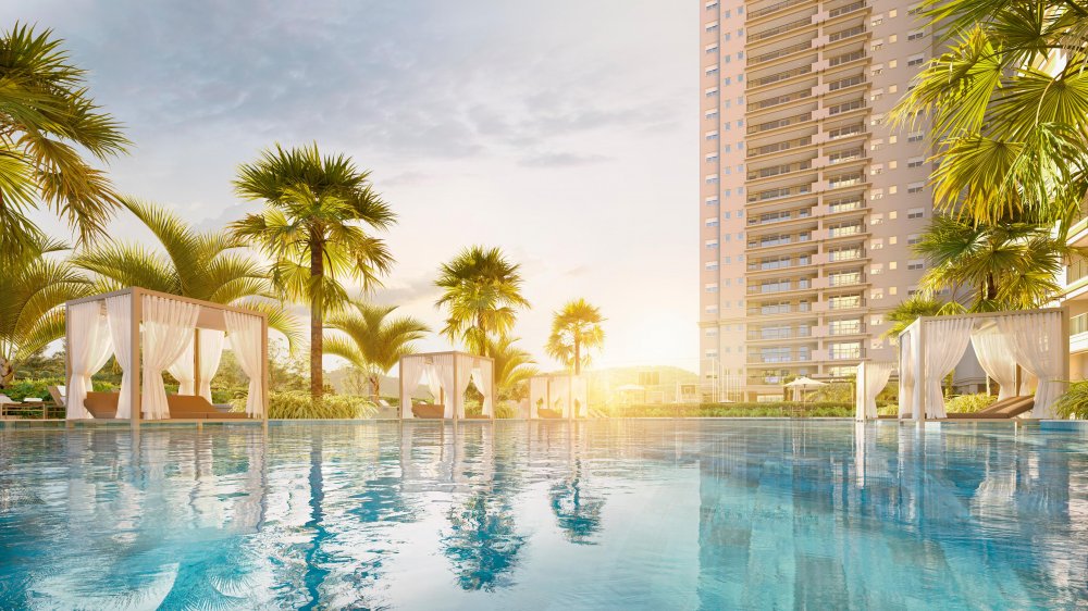 Piscina externa com cabanas, palmeiras e torre ao fundo