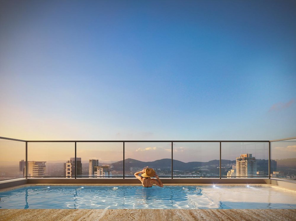 Piscina no rooftop com vista panorâmica da cidade ao entardecer