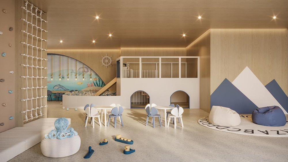 Brinquedoteca com parede de escalada, piscina de bolinhas e mesinhas infantis